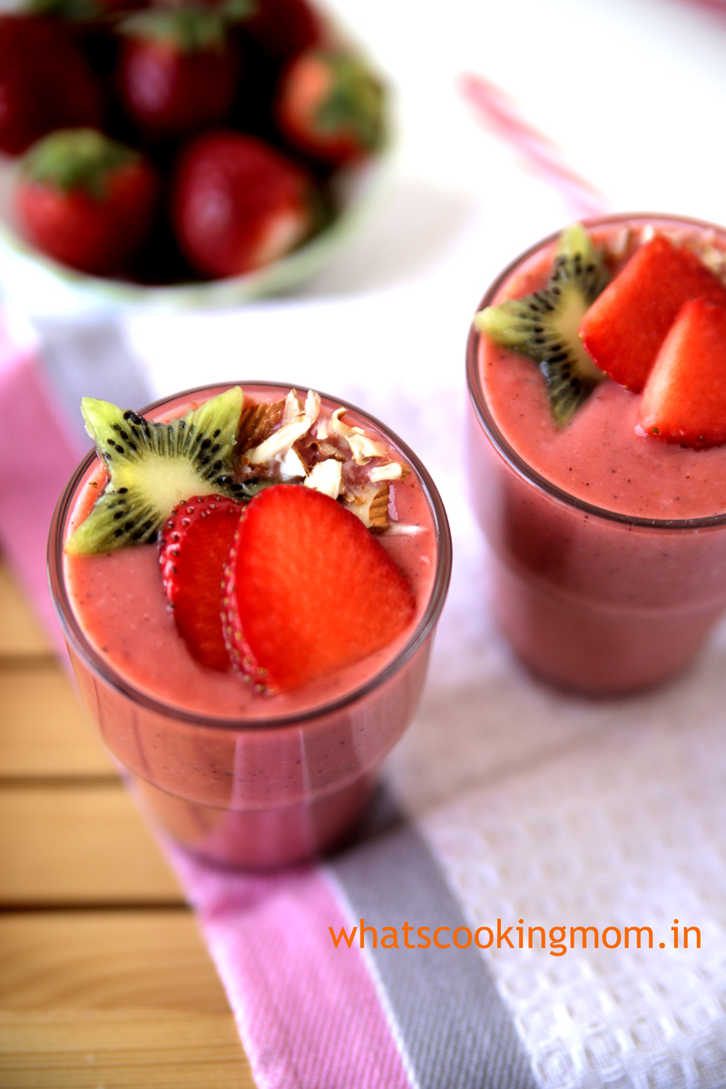 Strawberry Kiwi Banana Smoothie sprinkled with almond slivers and garnished with kiwi and strawberry slices.