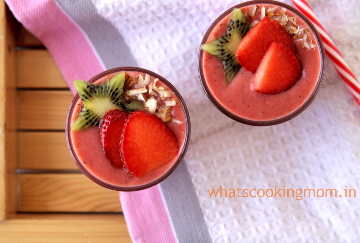 Fruit Smoothie sprinkled with almond slivers and garnished with kiwi and strawberry slices.